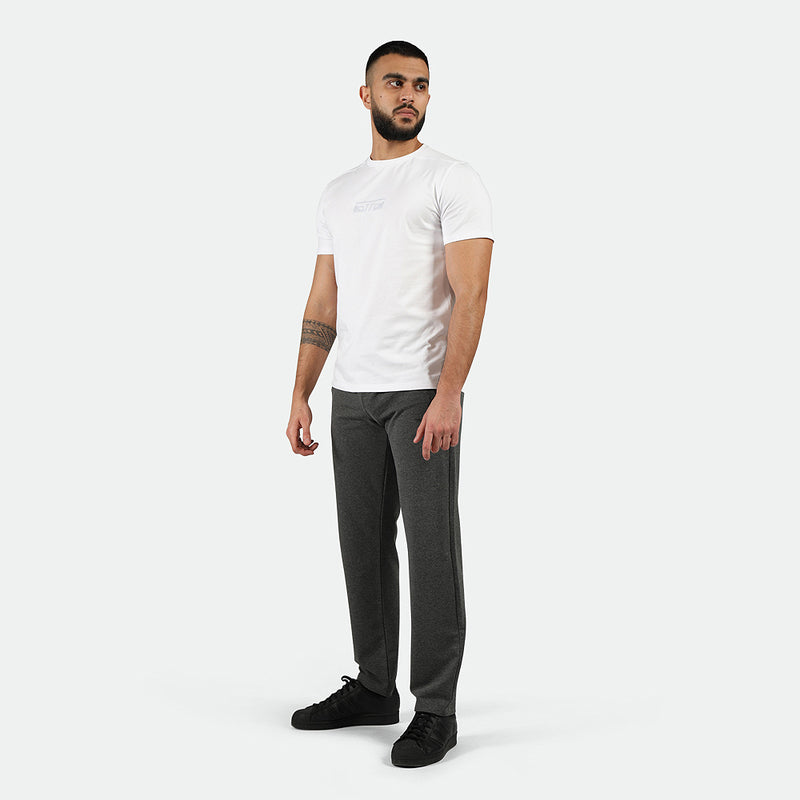 a fit man wearing t-shirt white with pants marl light grey with shoes black 