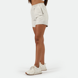 a fit woman stand at right and  wearing marl light grey  with shoes white ,plus the background is light grey 