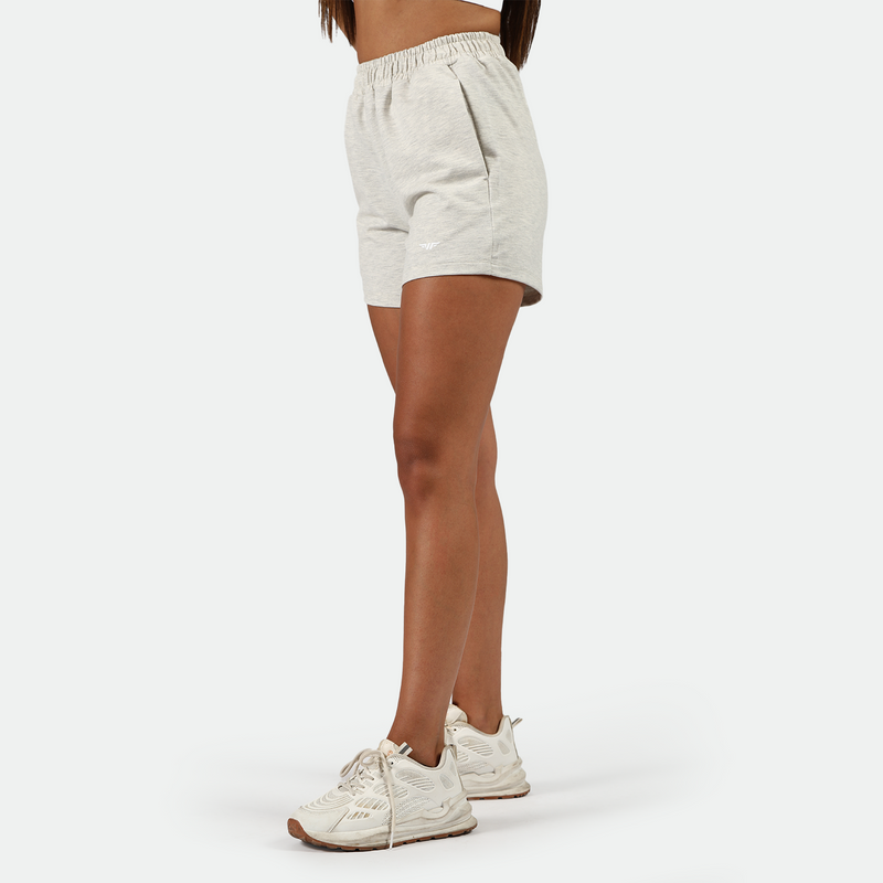 a fit woman stand at right and  wearing marl light grey  with shoes white ,plus the background is light grey 