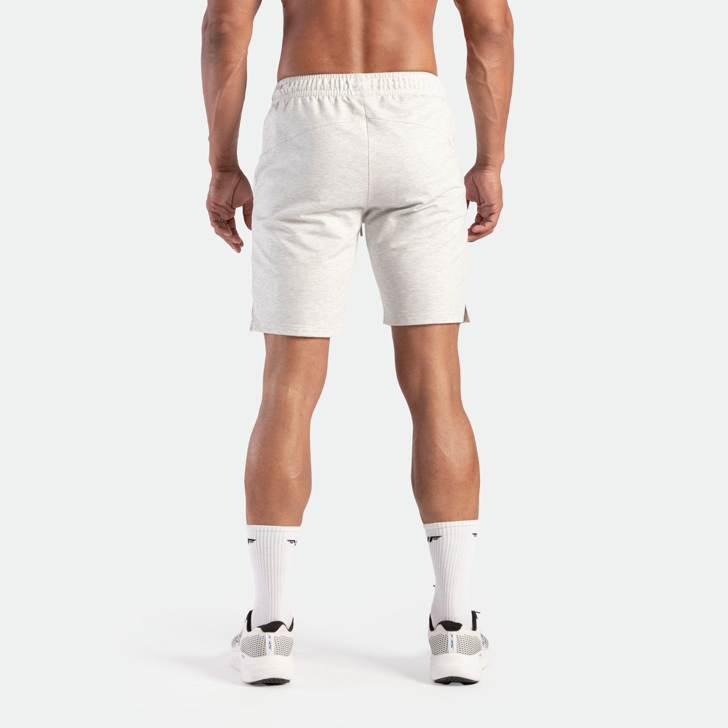 a back view for fit man wearing short marl light grey with socks white and shoes white 