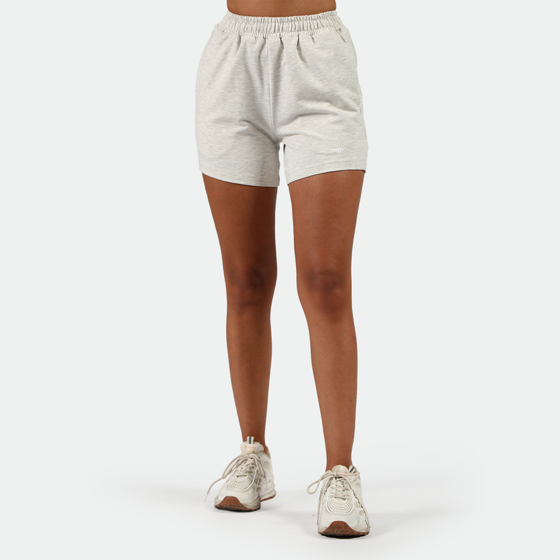 a fit woman wearing short marl light grey with shoes  white ,plus the background is light grey 