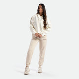 a fit woman wearing hoodie marshmallow with pants  beige ,plus sneakers white  