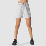 a fit woman wearing marl  light grey short with shoes black ,plus the background is light grey 