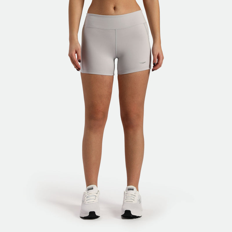 a fit woman wearing short grey with shoes white ,plus the background is light grey 