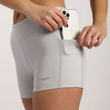 close up view for woman wearing short grey with pocket  and logo ,plus the backgrounds is light grey 