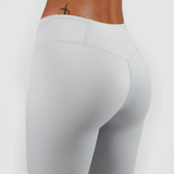 a back view for woman wearing legging grey with background is light grey 