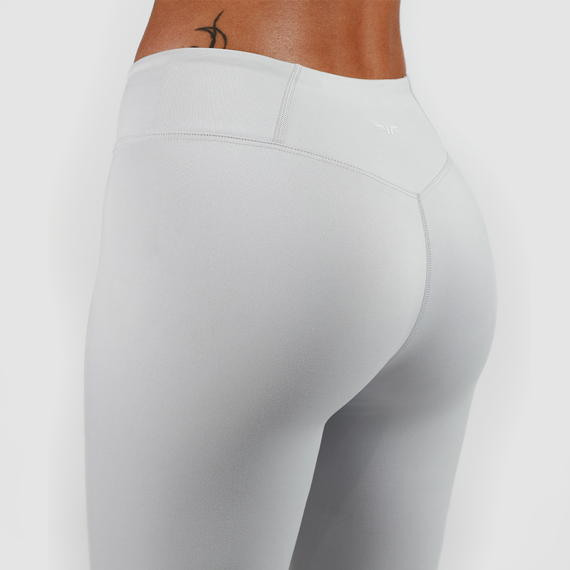 a back view for woman wearing legging grey with background is light grey 