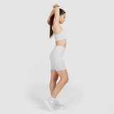 a woman wearing  a matching bra and  legging  with background  light grey