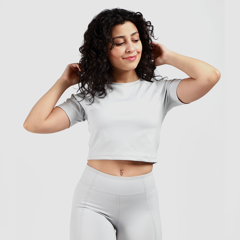 a fit woman wearing crop top  grey and short grey  