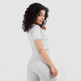 a fit woman wearing  matching crop top and short grey 