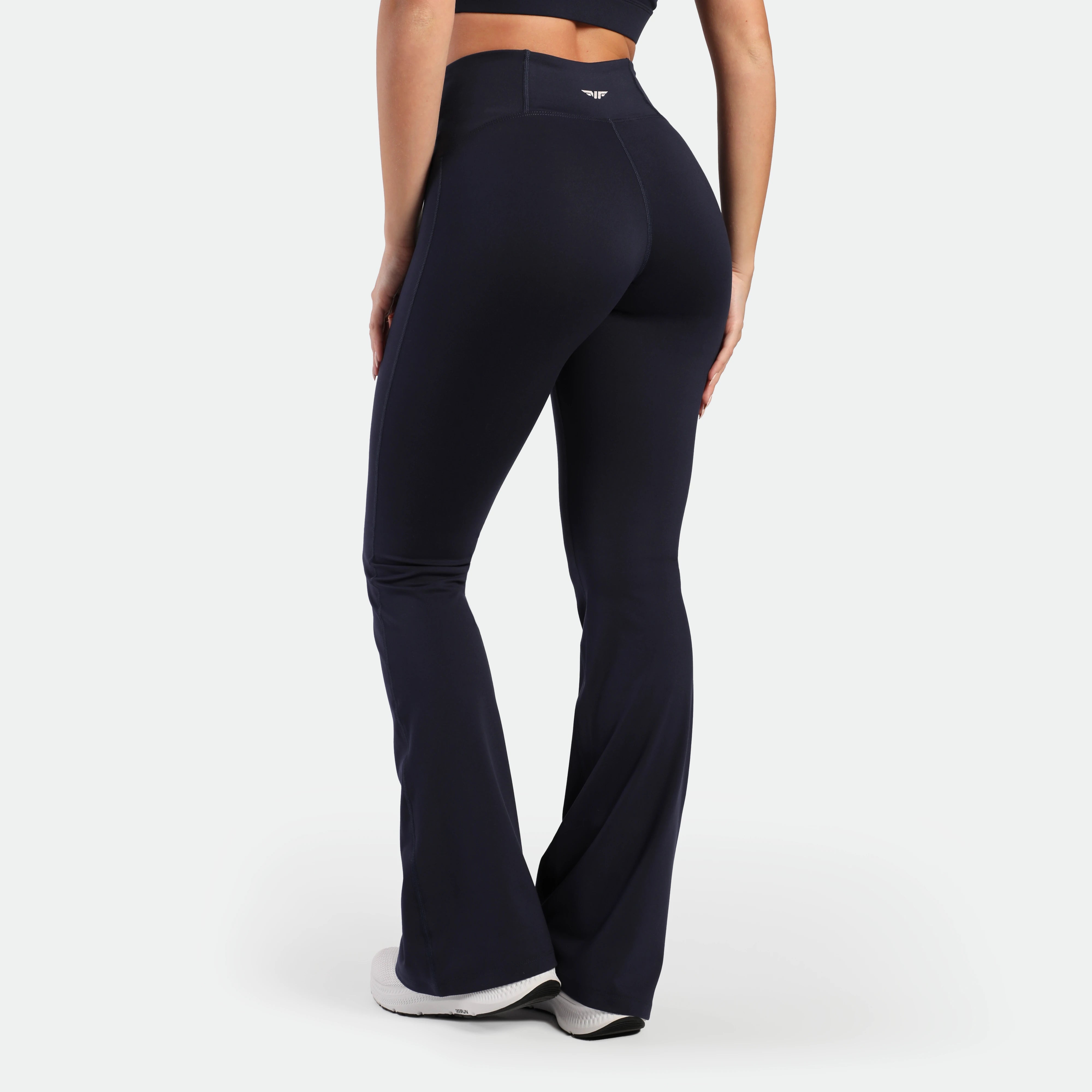 a back view for fit woman wearing legging flared legging navy with shoes
