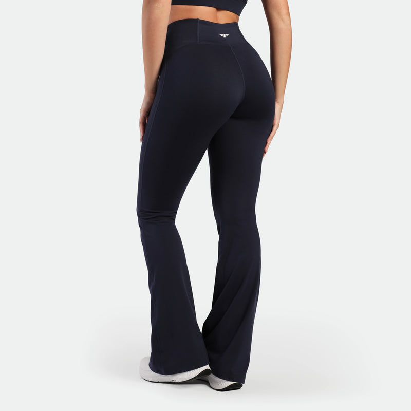 a back view for fit woman wearing legging flared legging navy with shoes