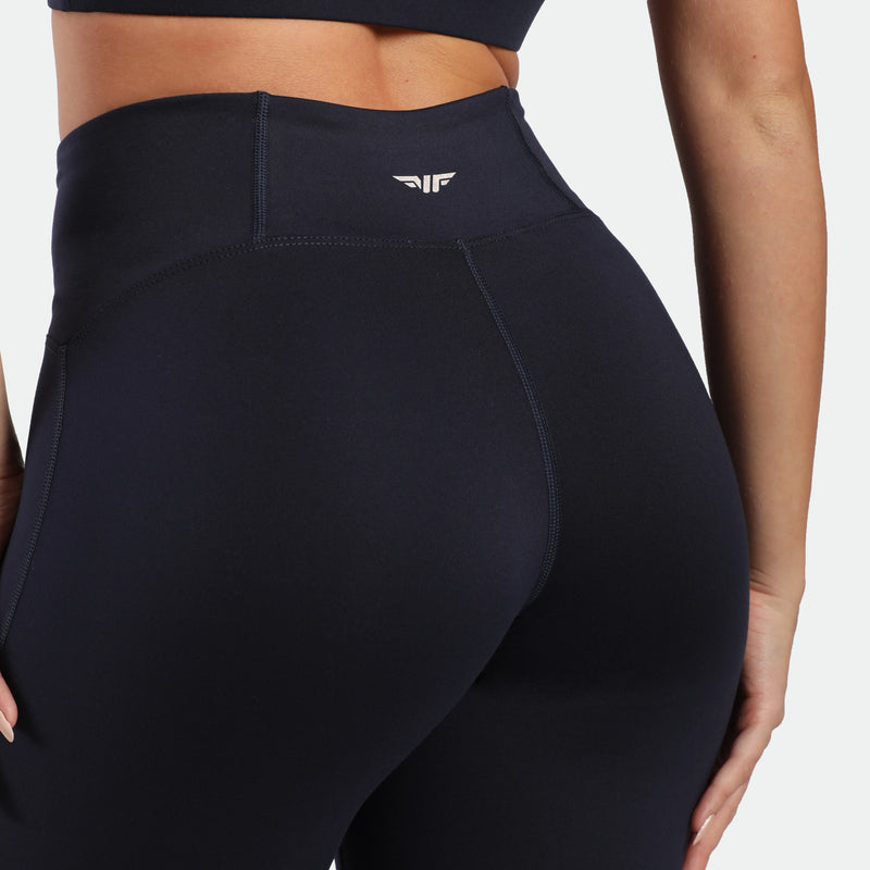 close up view for back view of woman wearing flared egging navy with logo white in half 