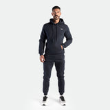 a fit man wearing matching navy set pants and shoes 