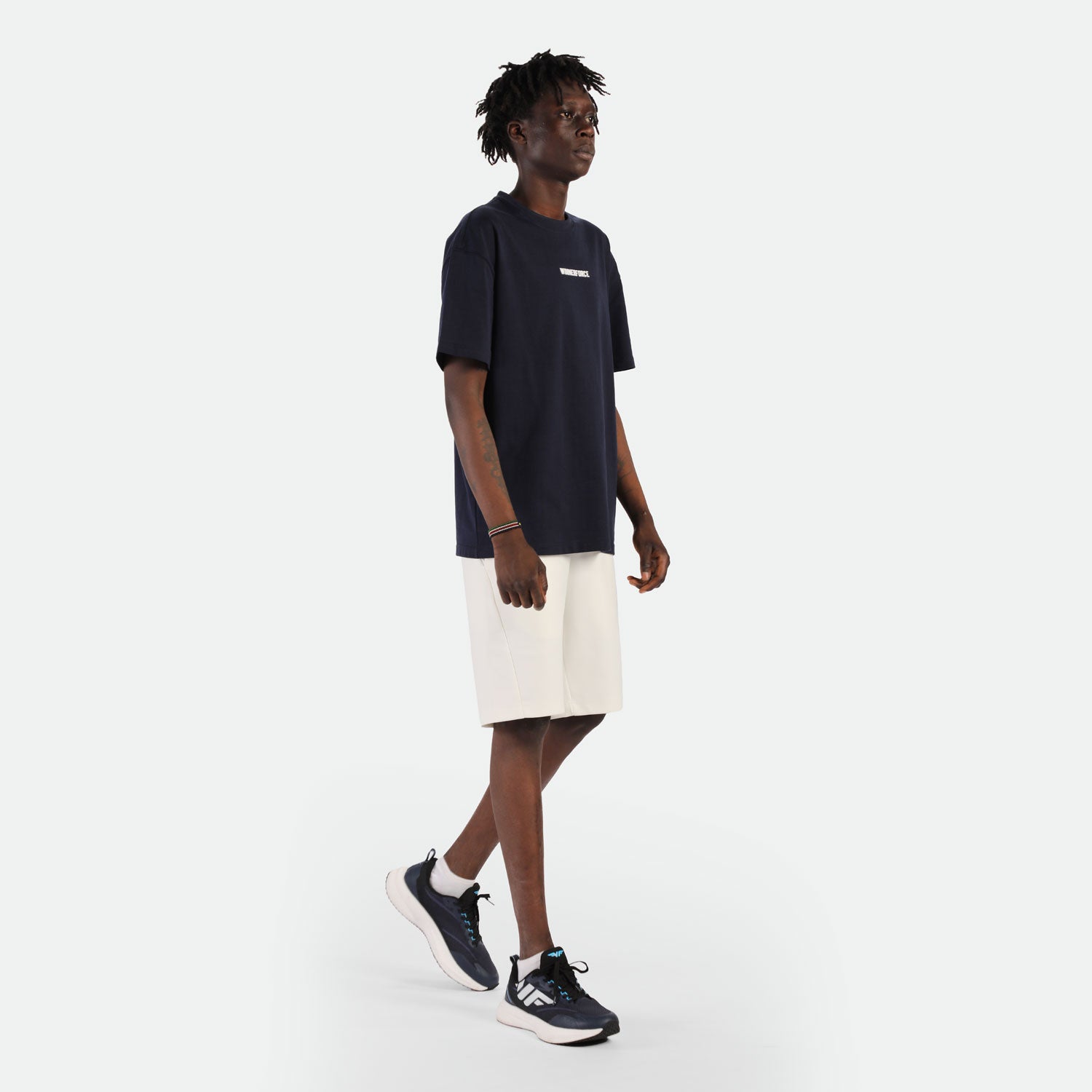 a fit man wearing t-shirt black with logo and short beige with shoes black 