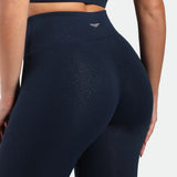 close up view for fit woman wearing legging navy blue terrazzo plus the logo in half  