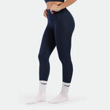 a fit woman stand at right and wearing legging navy blue terrazzo plus the socks white 