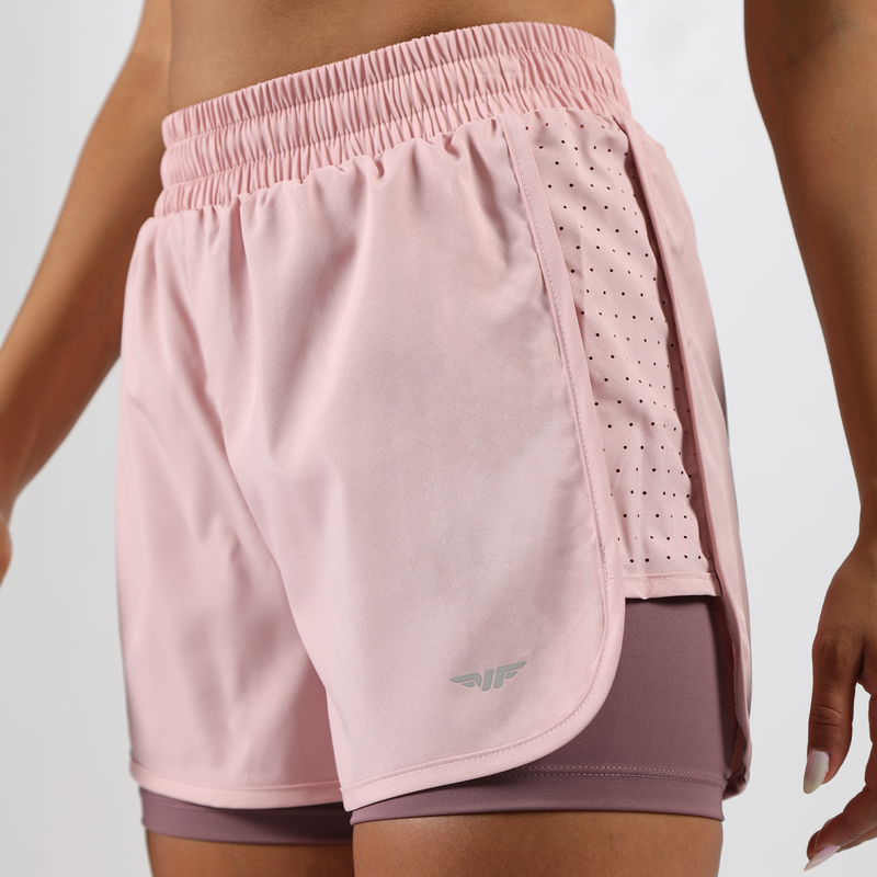 close up view for fit woman  wearing 
 pink nectar  short 2 in 1 ,plus the background is light grey 