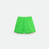 Bright green  athletic shorts laid flat on a light background. The shorts have a small white logo on the lower left side and feature a simple, sporty design
