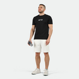 a fit man  wearing  t-shirt black  with short off white ,plus the sneakers 