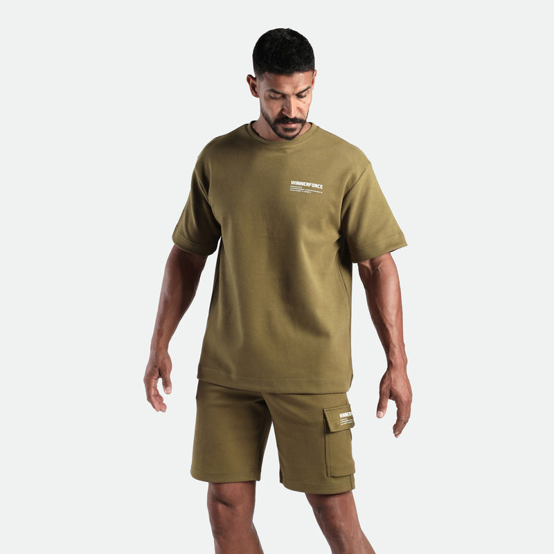 a fit man stand with pose and he wearing matching set olive drop t-shirt and short