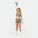 a fit woman stand with pose and wearing matching set olive grey  ,plus the socks white 