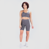 a fit woman wearing matching sports bra and egging grey with shoes white 