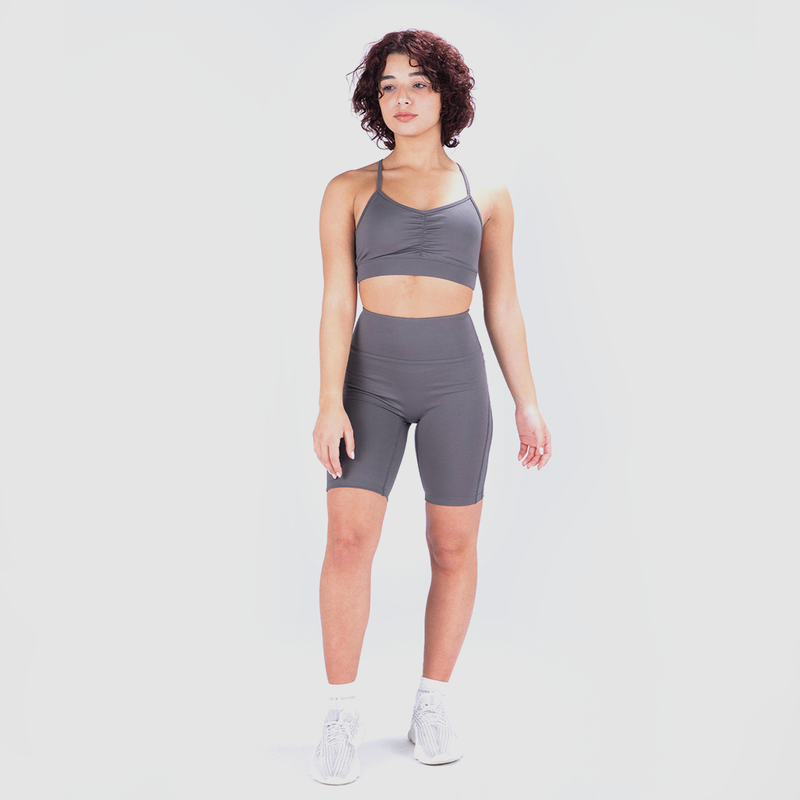 a fit woman wearing matching sports bra and egging grey with shoes white 