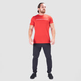 a fit man wearing t-shirt red with  logo 
 and pants black  plus sneakers 
