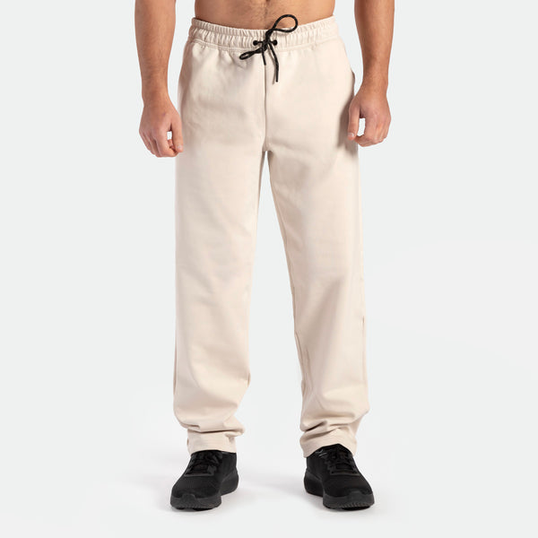 a fit man wearing  pants beige with shoes black 