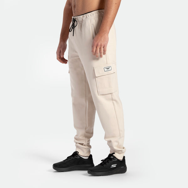 a fit man wearing  jogger pants light beige with shoes  black 