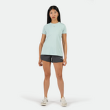 a fit woman stand with pose and look at the camera ,she wearing t-shirt pastel blue with short grey ,white sneakers ,plus the background is light grey 