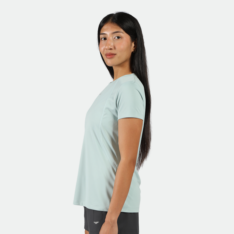 a fit woman stand at right and wearing t-shirt pastel blue with short grey ,plus the background is light grey 