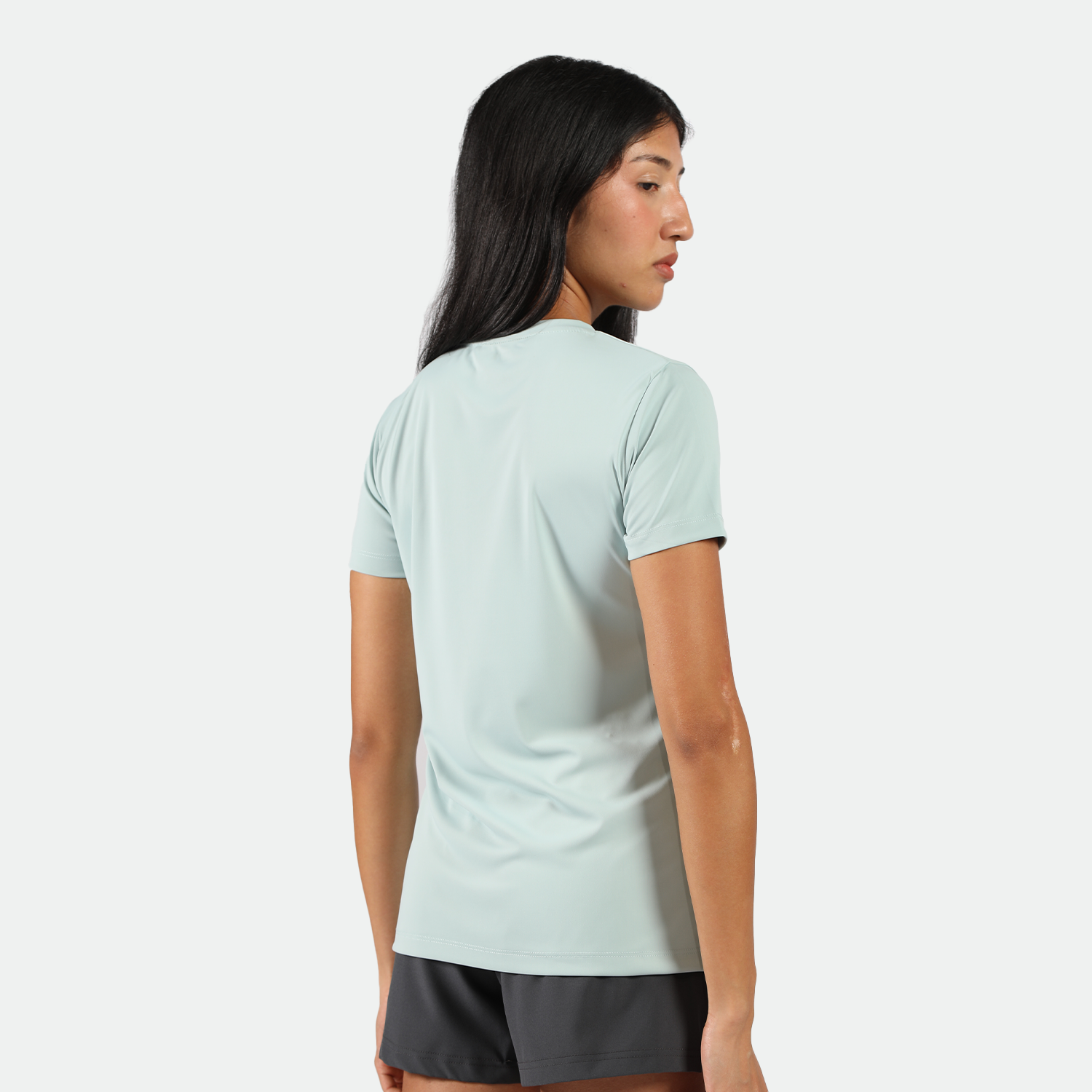 a back view for fit woman wearing t-shirt pastel blue with short  grey ,plus the background is light grey 