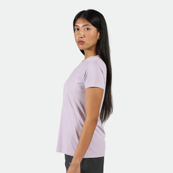 a fit woman stand at right and look at the camera ,she  wearing a light purple athletic t-shirt, black shorts,plus the background is light grey