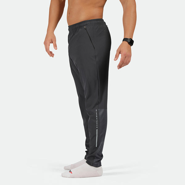 a fit man stand at right and wearing  pants phantom grey with socks white 