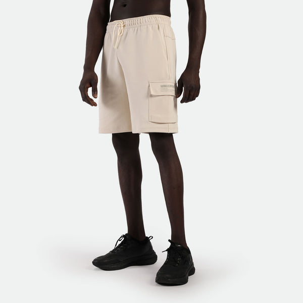 a fit man wearing short light beige with pocket and logo ,plus he wearing short black 