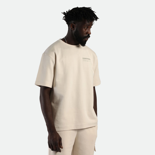 a fit man  stand at right and she wearing matching set light beige t-shirt with logo and short 