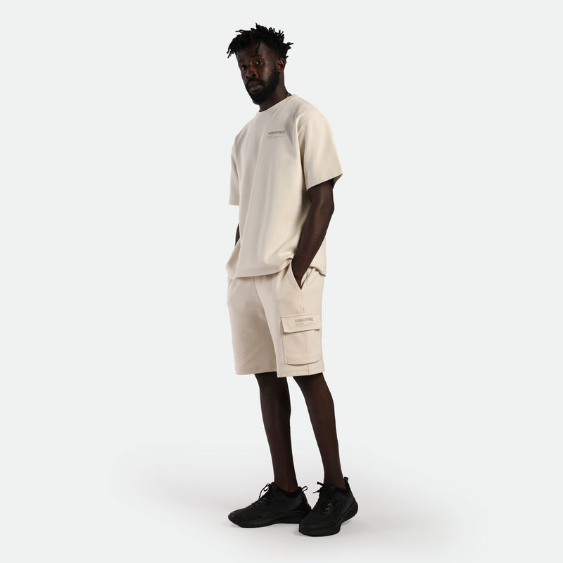 a fit man wearing matching set t-shirt and short light beige ,plus shoes black 