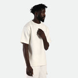 a fit man  wearing matching set t-shirt 
 off white with short beige 