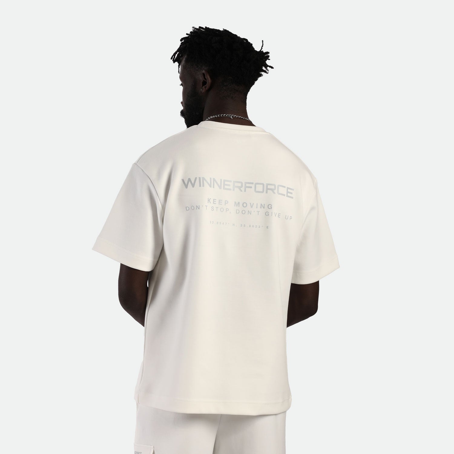 a back view for fit man wearing matching set  off white t-shirt with logo and  short 
