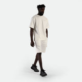 a fit man wearing matching set  of  white t-shirt with logo and short ,plus the shoes black 