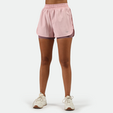a fit woman wearing pink nectar short 2 in 1 with shoes white ,plus the background is light grey   