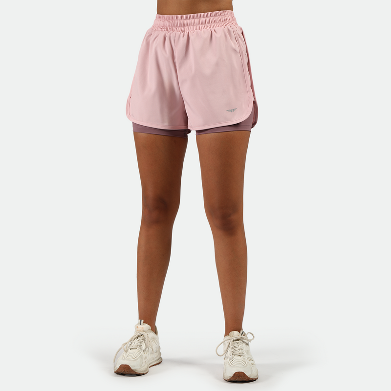 a fit woman wearing pink nectar short 2 in 1 with shoes white ,plus the background is light grey   