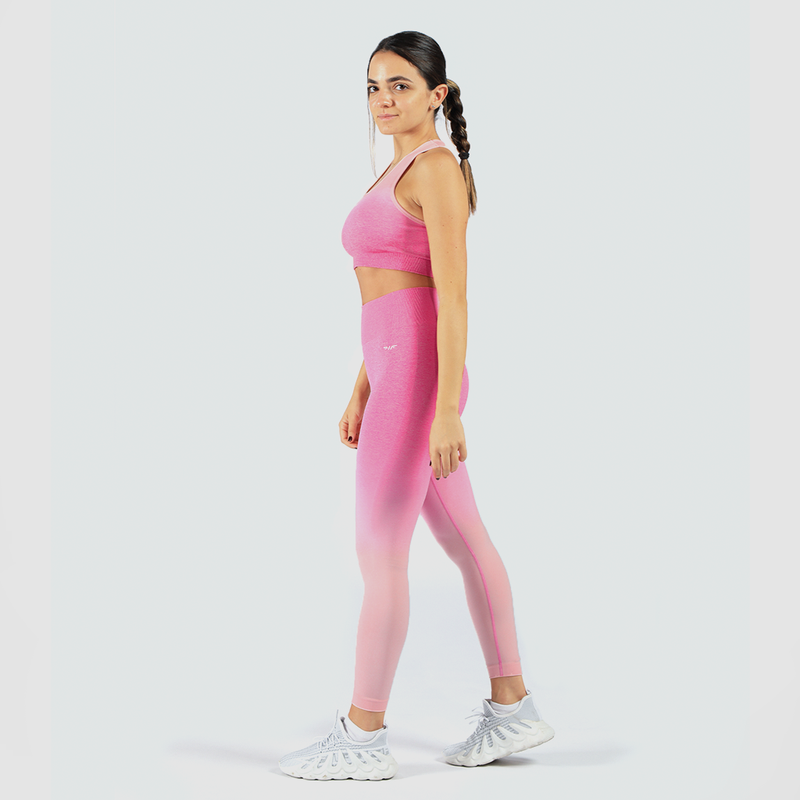  Woman looking at camera wearing matching bra and leggings with same pink color and logo