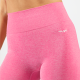  close up view of legging  pink made from a stretchy material, have logo white ,plus the background is light grey 