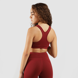 a back view for  woman wearing  matching  bra and legging  red ,the background light grey  