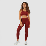 a woman wearing  matching bra and legging , she stand   and look at the camera