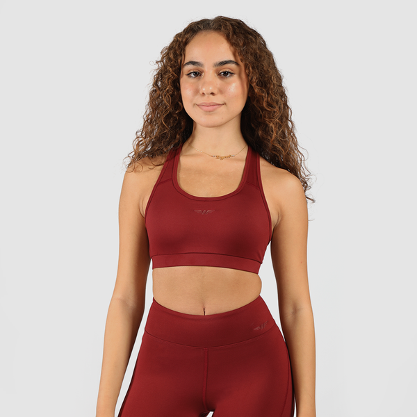 Woman wearing matching bra and leggings, standing in a natural pose, with logo  red and light gray background