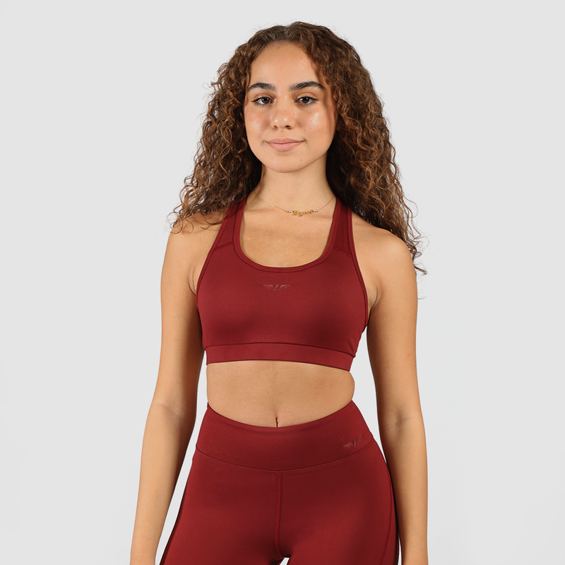 Woman wearing matching bra and leggings, standing in a natural pose, with logo  red and light gray background